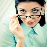 13785493-Serious-business-woman-looking-over-spectacles-Stock-Photo[1]